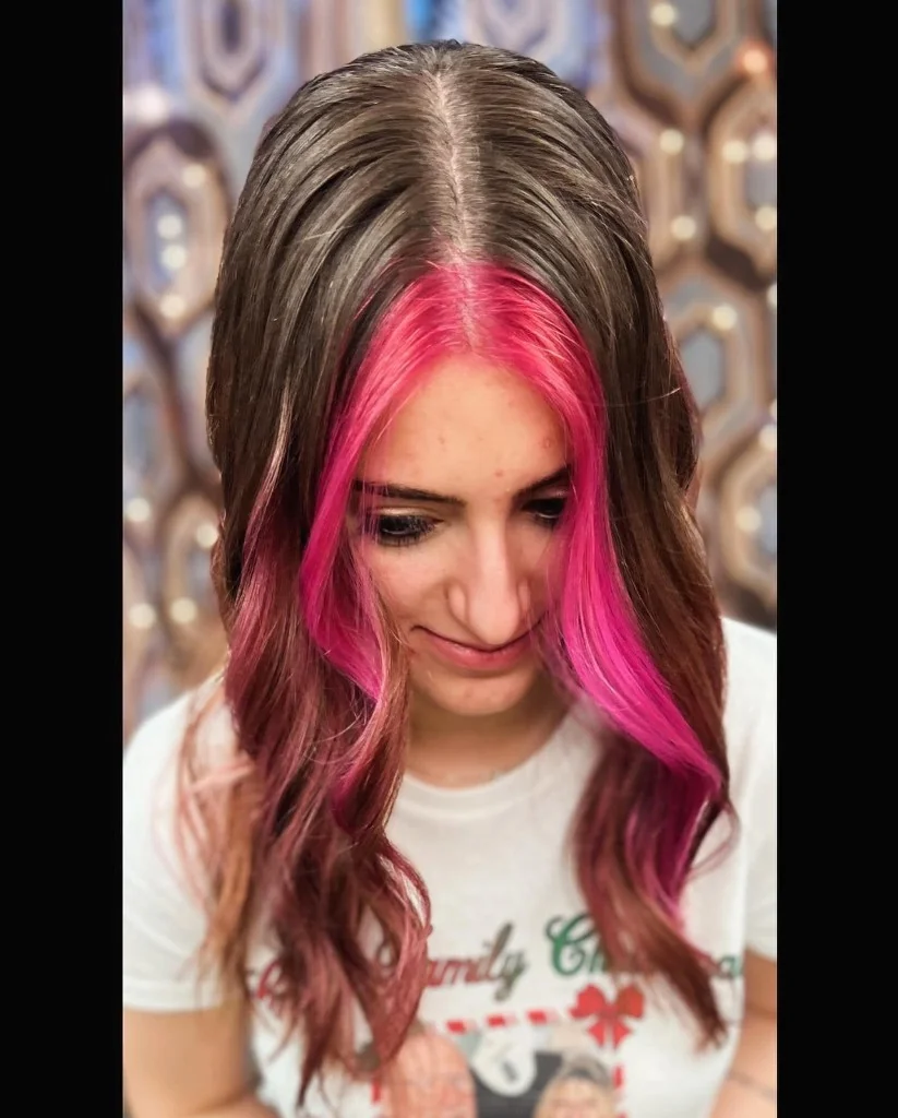 Long wavy brown hair with vibrant hot pink face-framing highlights, styled at Just Teasin' Salon.